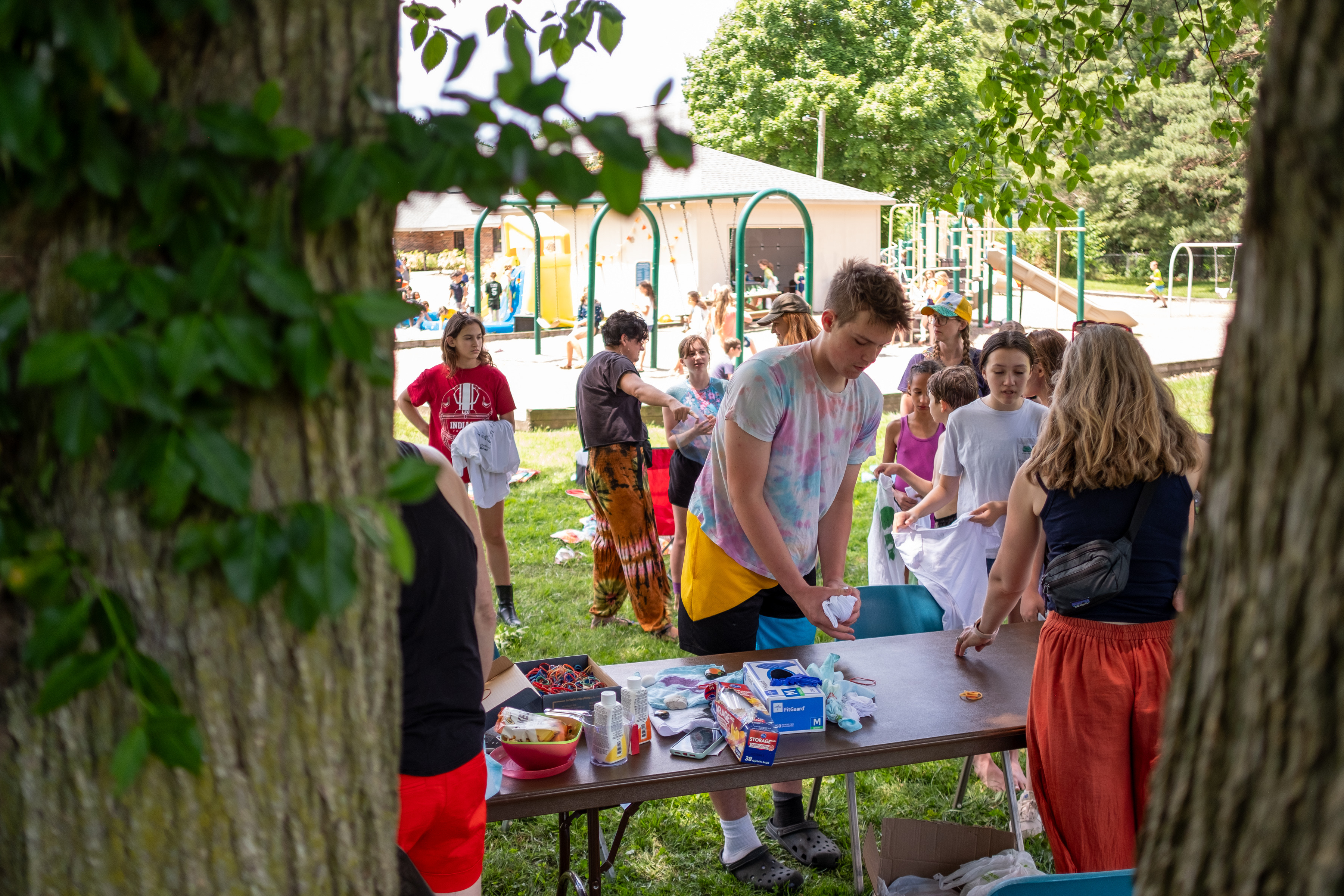 Kids and teens gathered at outdoor tables during a co-op activity