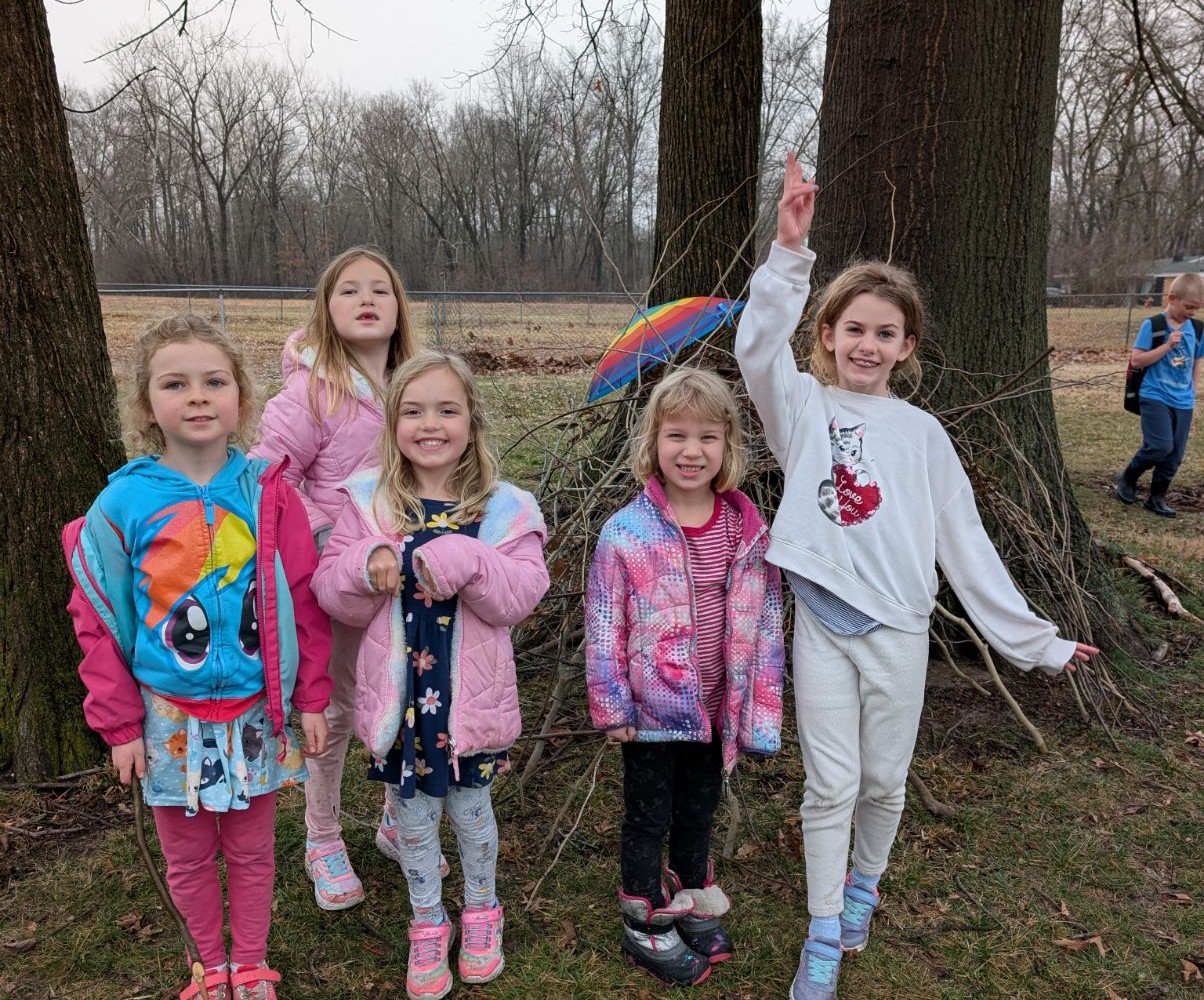 Kids posing outdoors by the trees during a co-op day